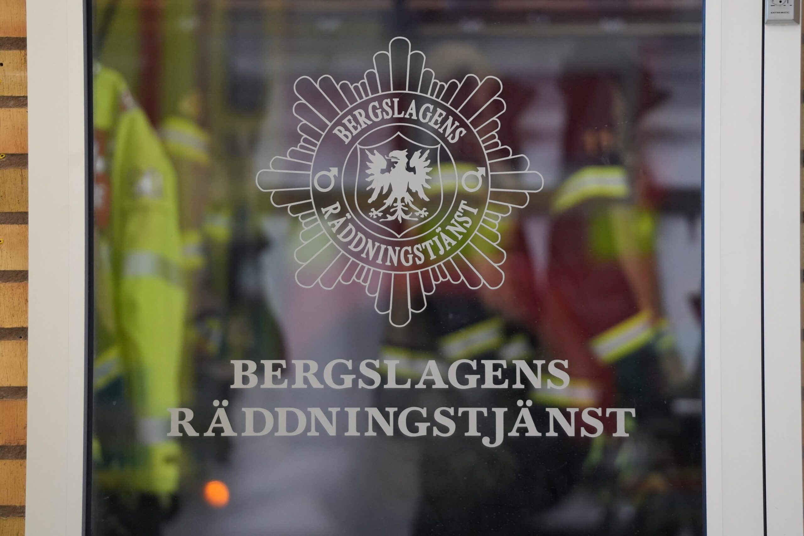 Glasdörr med Bergslagens Räddningstjänst- logotyp. Larmkläder i bakgrunden.